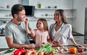 mom dad and daughter are cooking on kitchen happy family concept handsome man attractive young woman and their cute little daughter are making salad together healthy lifestyle